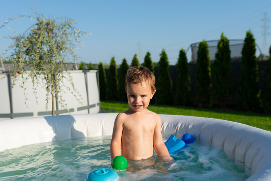 Young boy playing in inflatable outdoor hot tub