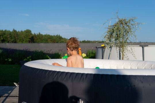 Young boy enjoying summer fun in inflatable hot tub