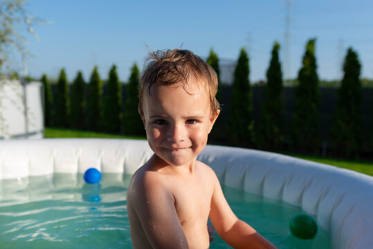 Happy child playing in inflatable garden pool