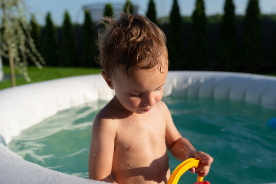 Young boy playing in inflatable pool during summer