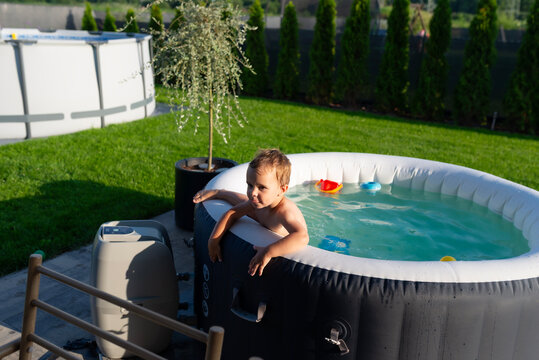 Young boy enjoying summer fun in inflatable hot tub