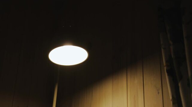 Title: Warm glowing lamp illuminating a wooden wall in a cozy rustic interior
