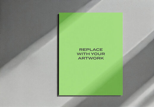 Vertical poster mockup displayed on a gray concrete wall with diagonal light shadows, realistic art presentation for graphic design, branding, advertising, editorial, print and digital content
