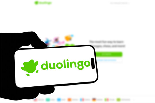 Kiel, Germany - 08-19-2026: Smartphone displaying US language learning platform Duolingo logo in front of companys webpage