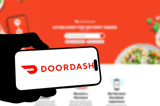 Kiel, Germany - 08-19-2026: Smartphone displaying US local commerce technology company DoorDash logo in front of companys webpage