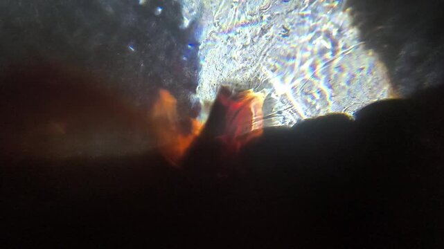 Abstract macro footage of colorful light refraction shifting through a glass marble lens.