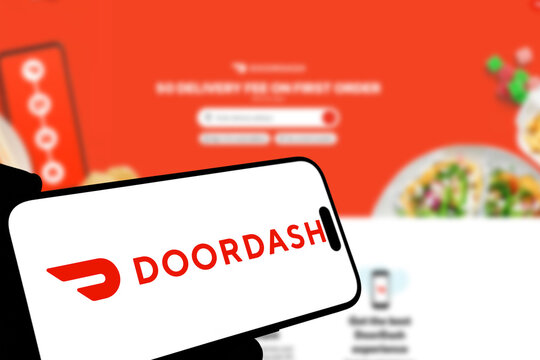 Kiel, Germany - 08-19-2026: Smartphone displaying US local commerce technology company DoorDash logo in front of companys webpage