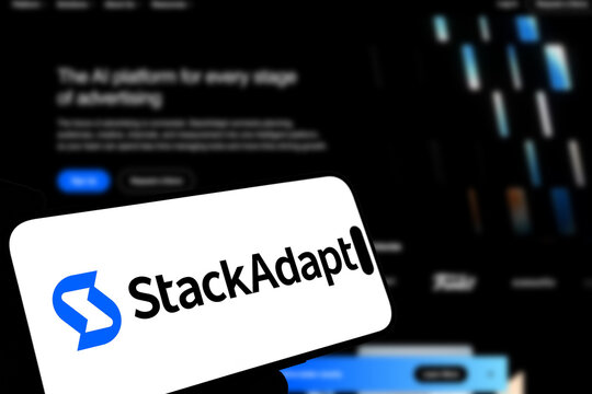 Kiel, Germany - 08-19-2026: Smartphone displaying Canadian advertising technology company StackAdapt logo in front of companys webpage
