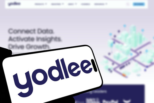 Kiel, Germany - 08-19-2026: Smartphone displaying US financial data platform Yodlee logo in front of companys webpage