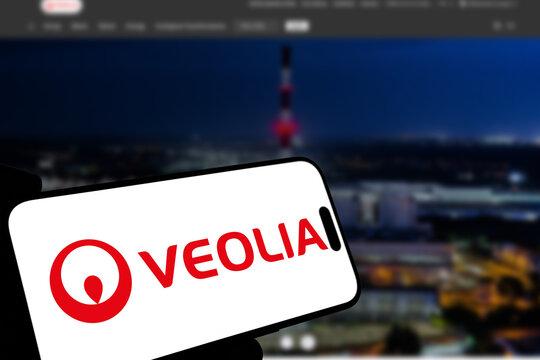 Kiel, Germany - 08-19-2026: Smartphone displaying French environmental services company Veolia logo in front of companys webpage