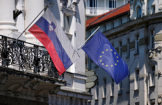 European Union flags and Slovenian national flag hanging from a building in Ljubljana