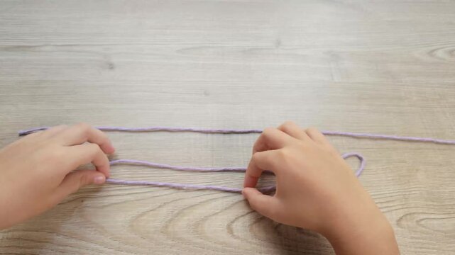 Child Hands Tying a Figure Eight Bend Knot with Purple Rope