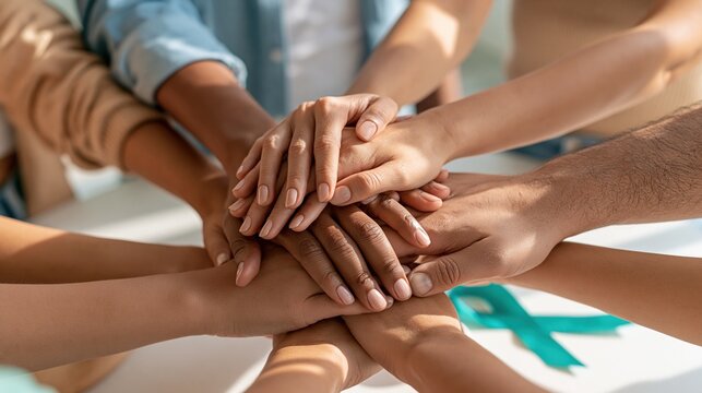 National Suicide Prevention Week: diverse group of hands stacked together in a circle of unity, overhead shot, bright natural daylight