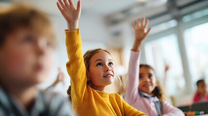 Fototapeta premium Elementary schoolchildren raising their hands in a bright classroom, representing active learning, participation, curiosity, education and student engagement.