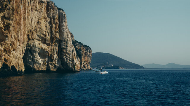 sailboat by cliffs and sea