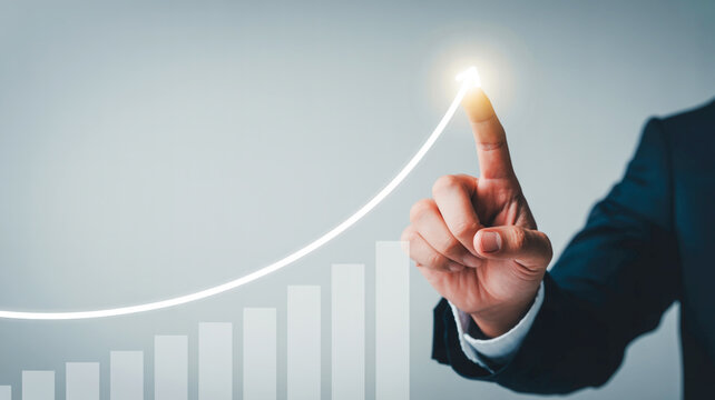 Businessman Hand Pointing to Rising Financial Growth Chart and Glowing Arrow