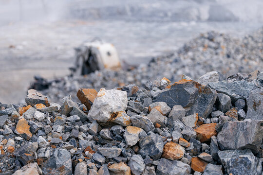 Gold and copper ore crushed rocks in mining quarry foreground, diamond industry