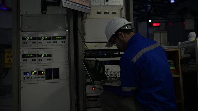 Professional engineer monitoring industrial automation system on digital screen in high-tech factory control room. Concept of smart manufacturing, technical data analysis, and modern engineering.