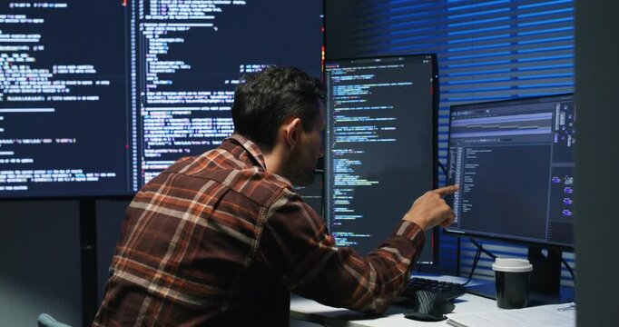 Single engineer monitors network traffic and firewall logs, hardening an enterprise application and responding to alerts in a corporate workspace.