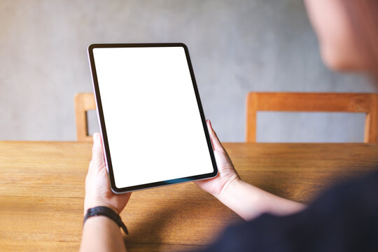 Mockup image of a woman holding digital tablet with blank white desktop screen