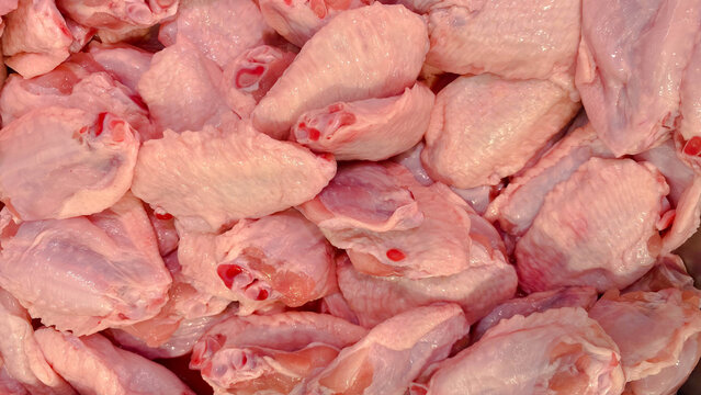 Full frame close-up texture of fresh raw chicken wings and drumettes