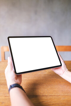 Vertical mockup image of a woman holding digital tablet with blank white desktop screen