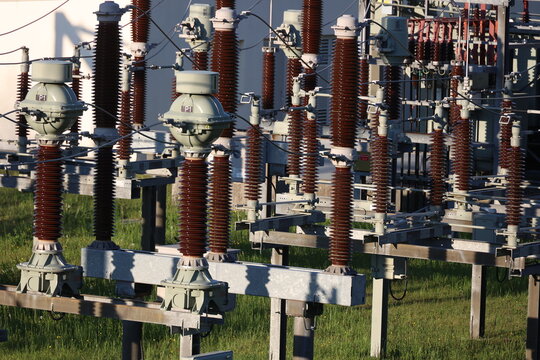 A large group of power lines and poles are in a field