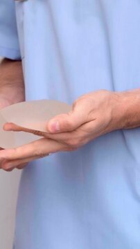 A plastic surgeon showing different breast implant options to a patient during a consultation in a modern medical clinic, healthcare and aesthetic medicine, patient care.