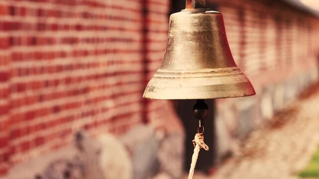 Small Vintage Bell Ringing Against Red Brick Wall