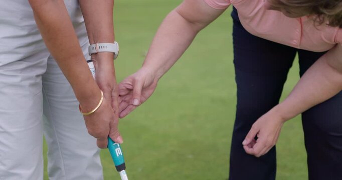 Sport, coach and woman training in golf on course for development in stroke and swing of club. Hands, closeup and mentor holding stick for player, athlete and student learning on pitch in sports game
