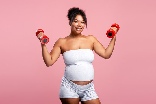Pregnant woman exercising with dumbbells for fitness and health