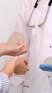 Surgeon explaining breast augmentation procedure with implants to woman, medical advertising, plastic surgery consultation, health clinic.