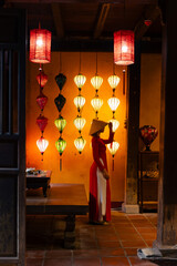 Asian female in traditional ao dai amongst lanterns in hoi an, vietnam lifestyle © Parilov