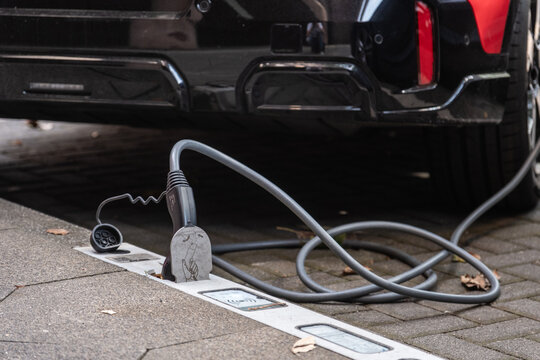 Ein E-Auto wird an einem Ladebordstein auf der K&Ouml; mit einem Kabel aufgeladen, D&uuml;sseldorf, Deutschland