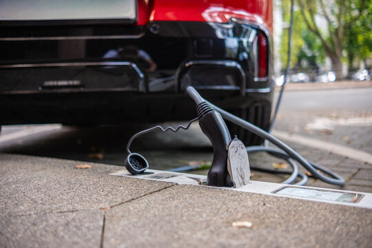 Ein E-Auto wird an einem Ladebordstein auf der K&Ouml; mit einem Kabel aufgeladen, D&uuml;sseldorf, Deutschland