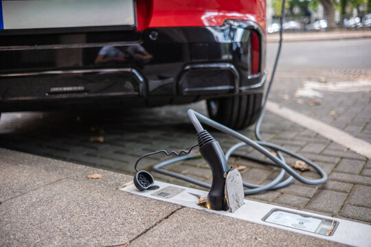 Ein E-Auto wird an einem Ladebordstein auf der K&Ouml; mit einem Kabel aufgeladen, D&uuml;sseldorf, Deutschland
