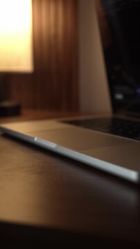 Hand Opening and Closing MacBook Lid in Warm Lighted Room