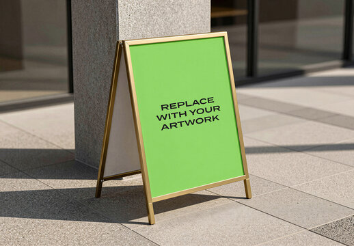 A-frame sign mockup with display panel and gold frame positioned on a tiled sidewalk near building entrance, realistic outdoor advertising presentation natural sunlight shadows
