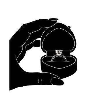 Hand holding open heart jewelry box with engagement ring silhouette