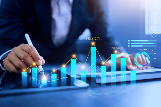 data analysis concept with businessman writing on dynamic financial graph curve and mark point on bar chart represents investment prediction data base