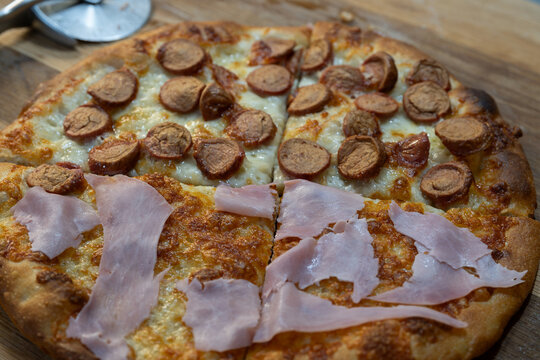 Homemade white pizza with sausage and cooked ham
