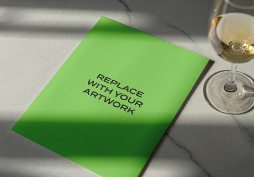 Brochure mockup on a marble surface with wine glass, realistic print presentation for branding, editorial design, and advertising display, blank