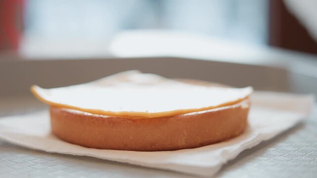 Hands lift filled sponge layer onto lower cake base, inspect filling, then align top layer for neat stacking, glossy finish and warm bakery presentation under soft backlight, with cake, sponge