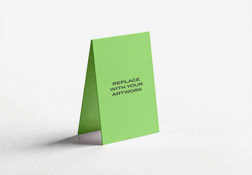 Paper tent card mockup standing upright on a white surface, realistic stationery presentation with text placeholder, graphic design template for business cards, brochures, or invitations