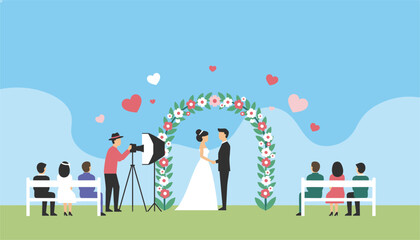 Fototapeta premium Romantic outdoor wedding ceremony featuring a bride and groom under a floral arch, with a photographer and seated guests.