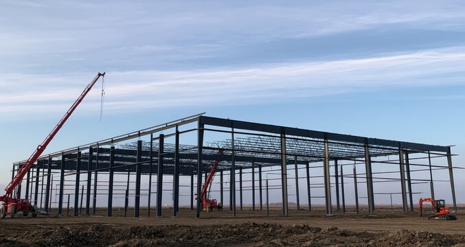 Steel framework of a large industrial building under construction outdoors