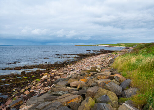 The rocky Scottish shoreline at John o' Groats, overlooking Pentland Firth in Caithness, which tourists mistakenly regard as the most northern point of Great Britain.