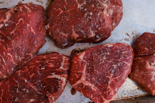 Fresh raw beef steaks seasoned with salt and pepper ready for cooking