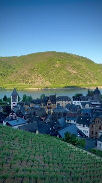 Bacharach, in the Rhine Valley, Germany, features charming medieval architecture with a prominent church spire, likely St. Peter's Church, standing tall among half-timbered houses. 