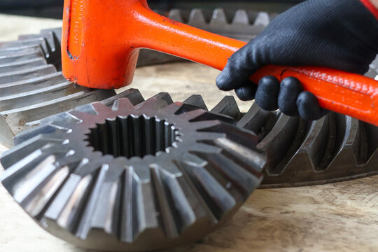 Mechanic using a dead blow hammer on a differential crown gear.